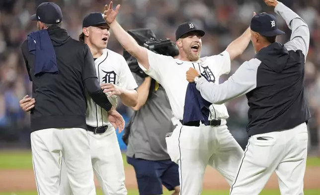 Members of the Detroit Tigers celebrate after the ninth inning of a baseball game against the Chicago White Sox, Friday, Sept. 27, 2024, in Detroit. (AP Photo/Carlos Osorio)