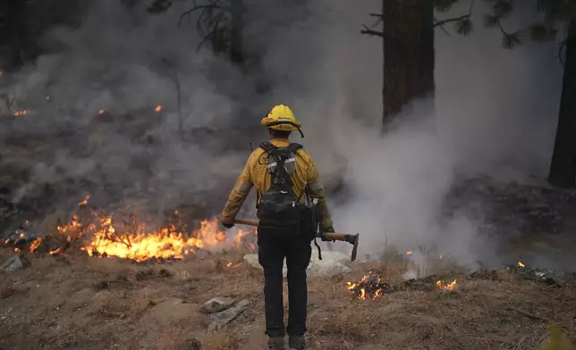 A firefighter works to contain the Bridge Fire Wednesday, Sept. 11, 2024, Wrightwood, Calif. (AP Photo/Eric Thayer)