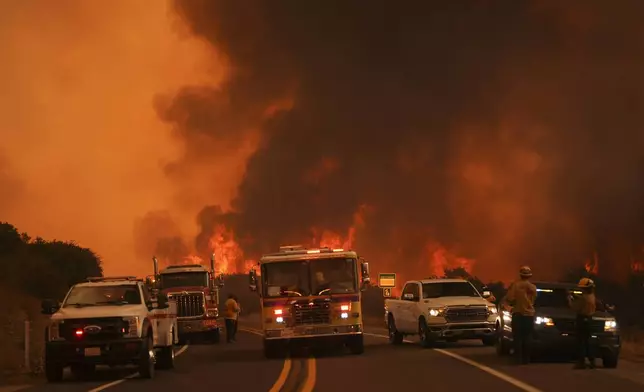 Firefighters monitor the Airport Fire as it advances Tuesday, Sept. 10, 2024, in El Cariso, an unincorporated community in Riverside County, Calif. (AP Photo/Eric Thayer)