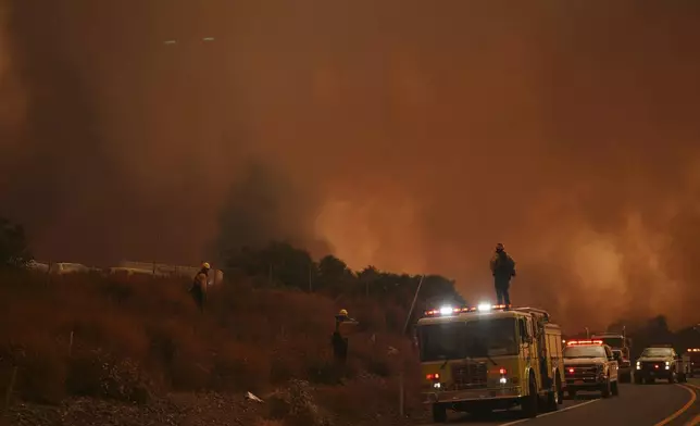 Firefighters monitor the Airport Fire as it advances Tuesday, Sept. 10, 2024, in El Cariso, an unincorporated community in Riverside County, Calif. (AP Photo/Eric Thayer)