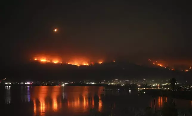 The Airport Fire is reflected on Lake Elsinore, Tuesday, Sept. 10, 2024, in Lake Elsinore, Calif. (AP Photo/Eric Thayer)