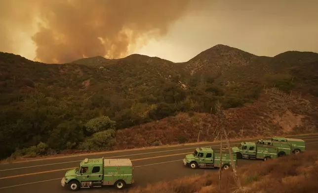 Firefighters stage under a plume of smoke set by the Line Fire, Monday, Sept. 9, 2024, near Angelus Oaks, Calif. (AP Photo/Eric Thayer)