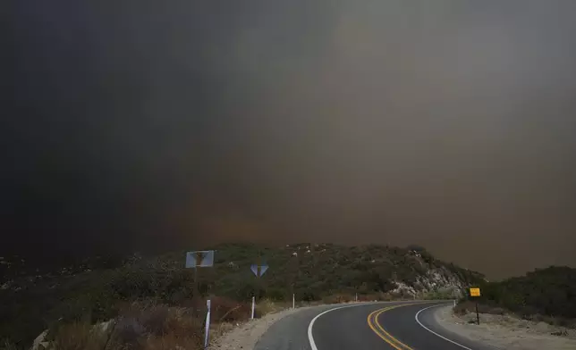 Smoke from the Airport Fire fills the airs over over Highway 74 Tuesday, Sept. 10, 2024, near Lake Elsinore, Calif. (AP Photo/Eric Thayer)