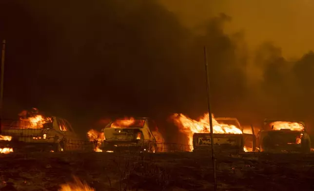 Vehicles burn as the Airport Fire sweeps through Tuesday, Sept. 10, 2024, in El Cariso, an unincorporated community in Riverside County, Calif. (AP Photo/Etienne Laurent)