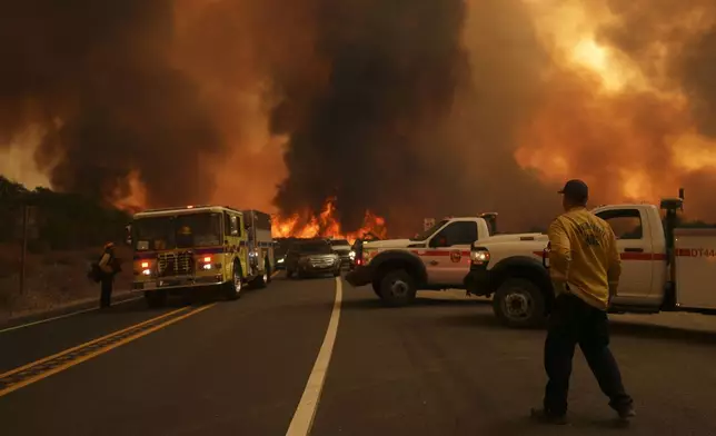 Firefighters monitor the Airport Fire as it advances Tuesday, Sept. 10, 2024, in El Cariso, an unincorporated community in Riverside County, Calif. (AP Photo/Eric Thayer)