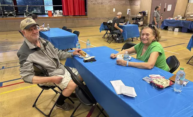 Rich Meyr, 82, left, and Evelyn Kelley, 77, sit at an evacuation center for those in the path of regional wildfires, Wednesday, Sept. 11, 2024, in Reno, Nevada. The two were the first — and so far only - arrivals at a new evacuation center set up Wednesday at a recreation center in south Reno where the Red Cross was prepared to handle 100 or more people if necessary. (AP Photo/Scott Sonner)