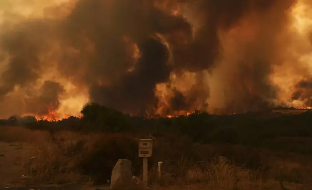 The Airport Fire crests over a mailbox Tuesday, Sept. 10, 2024, in El Cariso, an unincorporated community in Riverside County, Calif. (AP Photo/Eric Thayer)