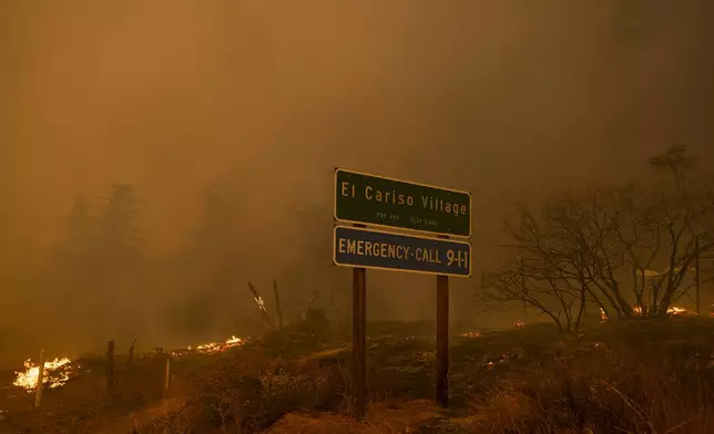 The Airport Fire surround a city limits sign Tuesday, Sept. 10, 2024, in El Cariso, an unincorporated community in Riverside County, Calif. (AP Photo/Etienne Laurent)