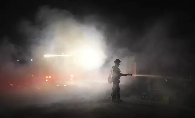 A firefighter battles the Airport Fire Tuesday, Sept. 10, 2024, in El Cariso, an unincorporated community in Riverside County, Calif. (AP Photo/Eric Thayer)