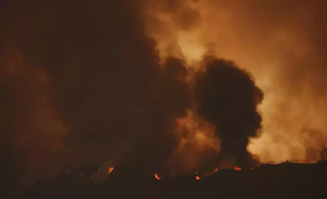 The Airport Fire burns on a mountain top Tuesday, Sept. 10, 2024, in El Cariso, an unincorporated community in Riverside County, Calif. (AP Photo/Eric Thayer)