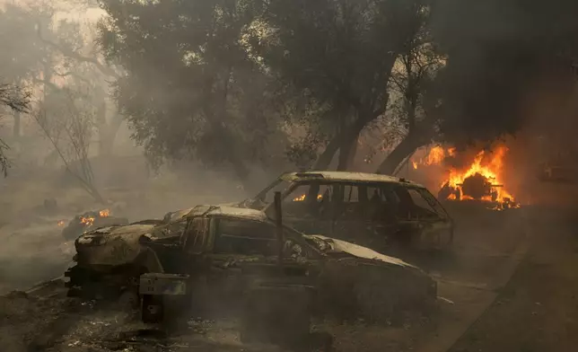 Charred vehicles sit on a property after the Airport Fire swept through Tuesday, Sept. 10, 2024, in El Cariso, an unincorporated community in Riverside County, Calif. (AP Photo/Eric Thayer)