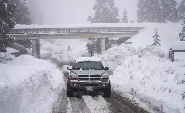 FILE - A truck drives along snow berms in Running Springs, Calif., Tuesday, Feb. 28, 2023. (AP Photo/Jae C. Hong, File)