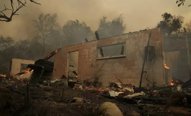 A structure burns after the Airport Fire swept through Tuesday, Sept. 10, 2024, in El Cariso, an unincorporated community in Riverside County, Calif. (AP Photo/Eric Thayer)