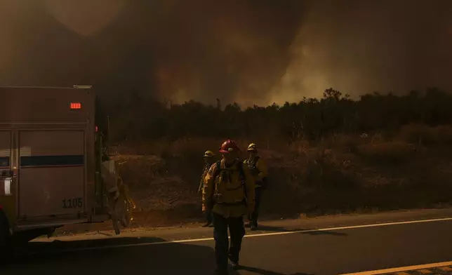 Firefighters monitor the Airport Fire as it advances Tuesday, Sept. 10, 2024, in El Cariso, an unincorporated community in Riverside County, Calif. (AP Photo/Eric Thayer)