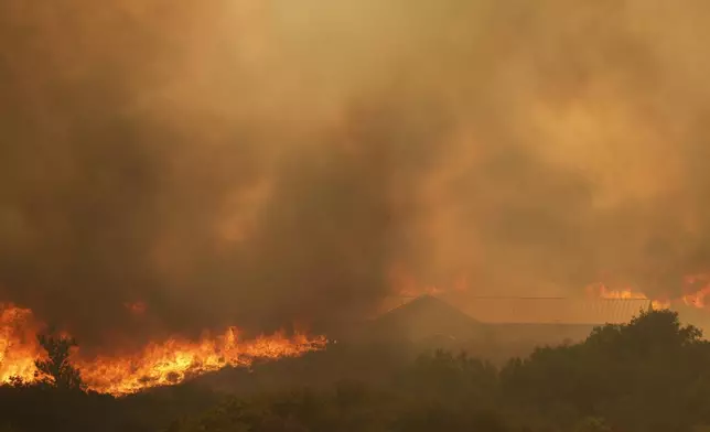 The Airport Fire engulfs a structure Tuesday, Sept. 10, 2024, in El Cariso, an unincorporated community in Riverside County, Calif. (AP Photo/Eric Thayer)