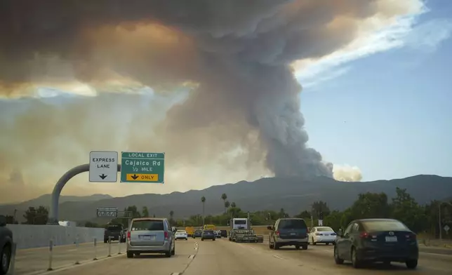 A plume of smoke created by the Airport Fire rises over motorists along I-15 Tuesday, Sept. 10, 2024, in El Cerrito, Calif. (AP Photo/Eric Thayer)