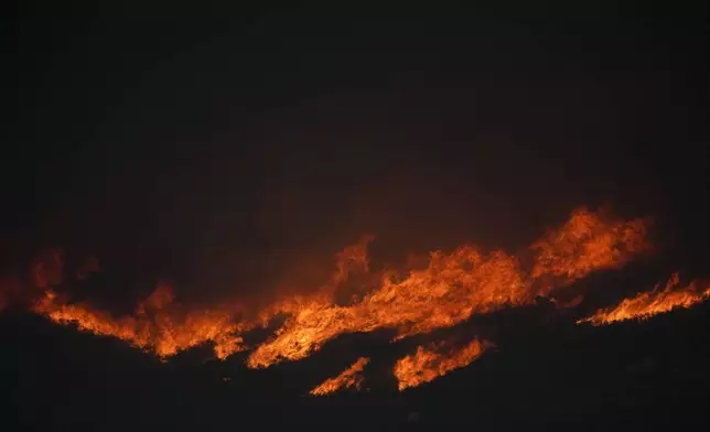 The Airport Fire burns on a mountain top Tuesday, Sept. 10, 2024, in El Cariso, an unincorporated community in Riverside County, Calif. (AP Photo/Eric Thayer)