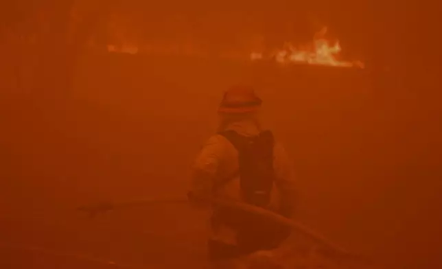 A firefighter battles the advancing Airport Fire Tuesday, Sept. 10, 2024, in unincorporated Riverside County, Calif. (AP Photo/Etienne Laurent)