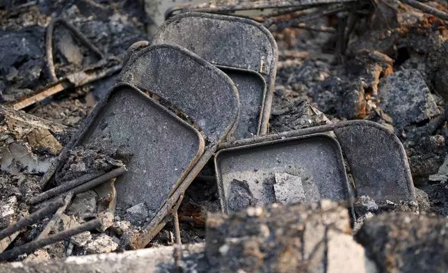 Chairs are stacked among the ruins in the aftermath of the Bridge Fire, Thursday, Sept. 12, 2024, in Wrightwood, Calif. (AP Photo/Eric Thayer)