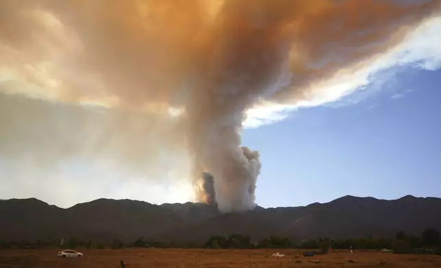 A plume of smoke created by the Airport Fire is seen on a mountain top Tuesday, Sept. 10, 2024, in Temescal Valley, Calif. (AP Photo/Eric Thayer)