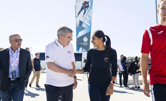 International Olympic Committee President Thomas Bach talks with long-track speedskater Shruti Kotwal as they walk toward the Utah Olympic Oval in Kearns, Utah, Saturday, Sept. 28. 2024. (Isaac Hale/The Deseret News via AP)