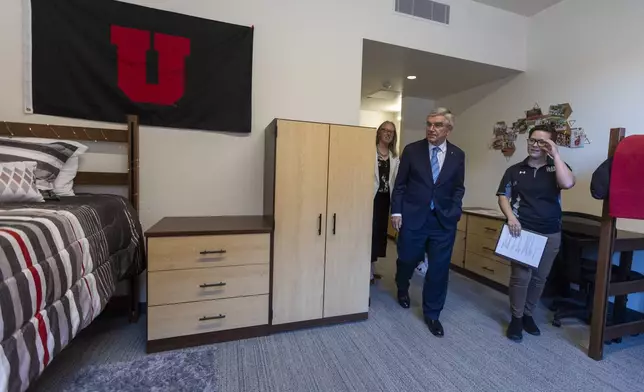 Rachel Aho, senior director of housing operations for the University of Utah, right, gives International Olympic Committee President Thomas Bach, center, a tour of housing in Kahlert Village as he leads a delegation visiting ahead of the 2034 Winter Olympics, at University of Utah in Salt Lake City on Friday, Sept. 27, 2024. (Brice Tucker/The Deseret News via AP)