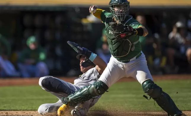 New York Yankees' Aaron Judge is forced out at home by Oakland Athletics catcher Shea Langeliers during the ninth inning of a baseball game in Oakland, Calif., Sunday, Sept. 22, 2024. (AP Photo/Nic Coury)