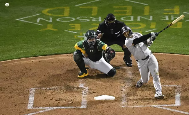 New York Yankees' Gleyber Torres, right, hits against the Oakland Athletics during the fourth inning of a baseball game Friday, Sept. 20, 2024, in Oakland, Calif. (AP Photo/Eakin Howard)