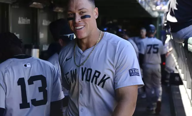 New York Yankees' Aaron Judge celebrates with teammates in the dugout after scoring on a throwing error by the catcher during the sixth inning of a baseball game against the Chicago Cubs in Chicago, Saturday, Sept. 7, 2024. (AP Photo/Paul Beaty)