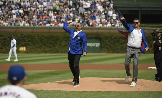 Members of the 2024 Chicago Cubs Hall of Fame class Kerry Wood, front right, and Aramis Ramirez, center, throw out ceremonial first pitches before a baseball game between the Cubs and the New York Yankees in Chicago, Sunday, Sept. 8, 2024. (AP Photo/Paul Beaty)