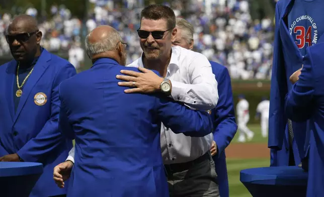 New member of the Chicago Cubs Hall of Fame Kerry Wood, right, hugs fellow Hall of Fame member Billy Williams, left, before a baseball game between the Chicago Cubs and New York Yankees in Chicago, Sunday, Sept. 8, 2024. (AP Photo/Paul Beaty)