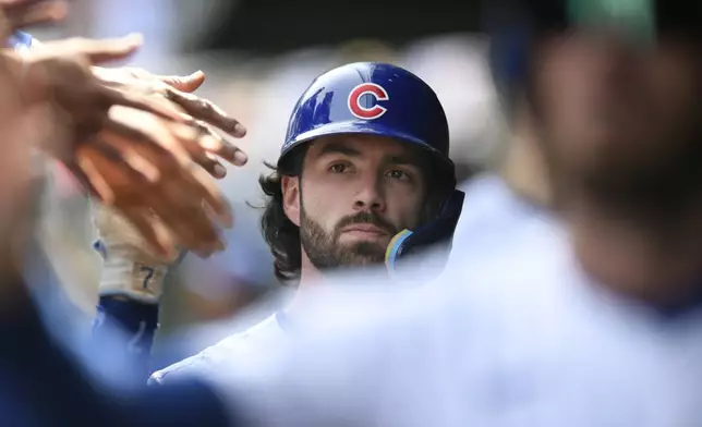 Chicago Cubs' Dansby Swanson celebrates with teammates in the dugout after scoring on a two-RBI single by Isaac Paredes during the first inning of a baseball game against the New York Yankees in Chicago, Sunday, Sept. 8, 2024. (AP Photo/Paul Beaty)