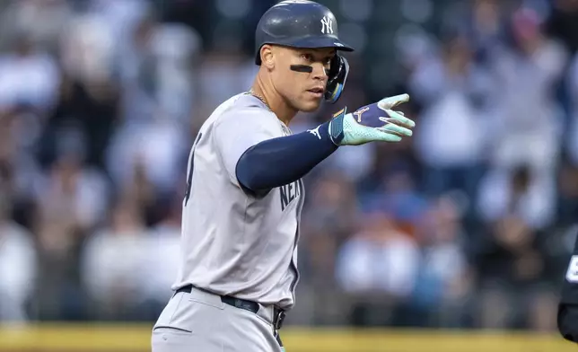 New York Yankees' Aaron Judge gestures to the dugout after hitting a two-run double during the first inning of a baseball game against the Seattle Mariners, Tuesday, Sept. 17, 2024, in Seattle. (AP Photo/Stephen Brashear)