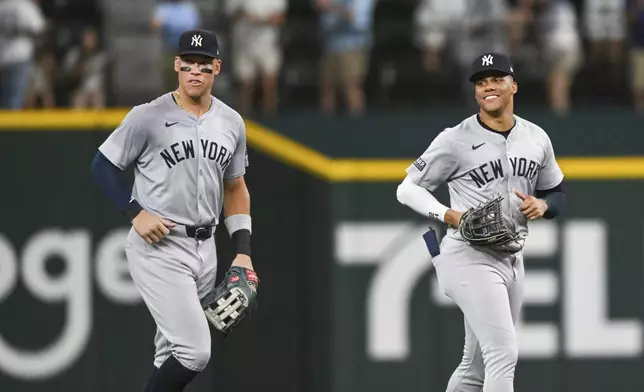 New York Yankees outfielder Aaron Judge, left, and teammate Juan Soto, right, celebrate after a win in a baseball game against the Texas Rangers, Monday, Sept. 2, 2024, in Arlington, Texas. (AP Photo/Albert Pena)