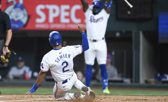 Texas Rangers' Marcus Semien (2) slides safely to home plate on a double hit by teammate Josh Smith in the fourth inning of a baseball game against the New York Yankees, Monday, Sept. 2, 2024, in Arlington, Texas. (AP Photo/Albert Pena)