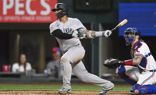 New York Yankees' Gleyber Torres, left, follows through on a two-run double in the third inning of a baseball game against the Texas Rangers, Monday, Sept. 2, 2024, in Arlington, Texas. (AP Photo/Albert Pena)