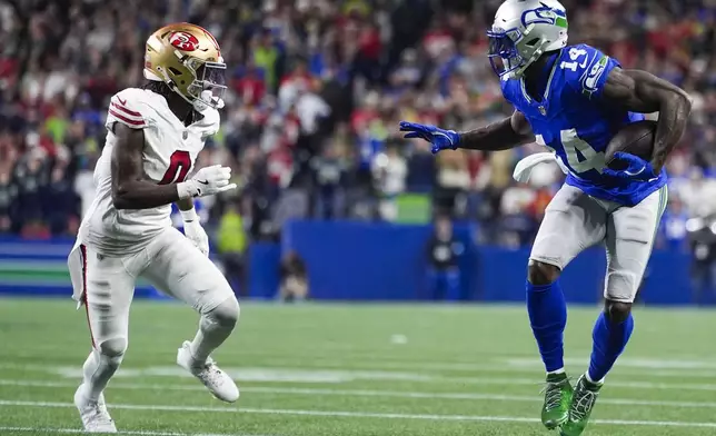 Seattle Seahawks wide receiver DK Metcalf, right, runs the ball against San Francisco 49ers cornerback Renardo Green, left, during the second half of an NFL football game Thursday, Oct. 10, 2024 in Seattle. (AP Photo/Lindsey Wasson)