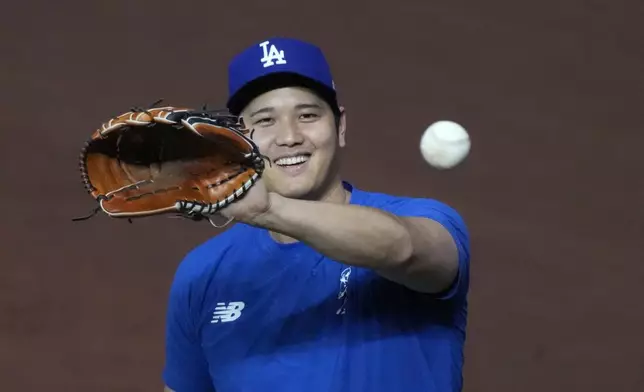 FILE - Los Angeles Dodgers' Shohei Ohtani, of Japan, warms up before the start of a baseball game against the Miami Marlins, Wednesday, Sept. 18, 2024, in Miami. (AP Photo/Wilfredo Lee, File)