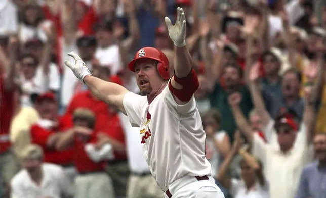 FILE - St. Louis Cardinals' Mark McGwire reacts as he watches his 61st home run of the season, in the first inning off Chicago Cubs pitcher Mike Morgan, Monday, Sept. 7, 1998, at Busch Stadium in St. Louis. (AP Photo/Ed Reinke)