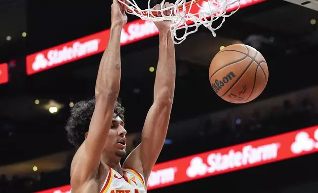 Atlanta Hawks forward Zaccharie Risacher (10) scores in the first half of a preseason NBA basketball game against the Philadelphia 76ers Monday, Oct. 14, 2024, in Atlanta. (AP Photo/John Bazemore)