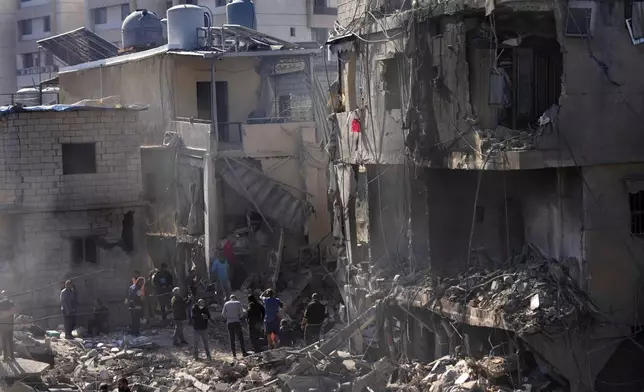 Rescue workers search for victims at the site of Israeli airstrikes that destroyed buildings facing the city's main government hospital in a densely-populated neighborhood, in southern Beirut, Lebanon, Tuesday, Oct. 22, 2024. (AP Photo/Hussein Malla)