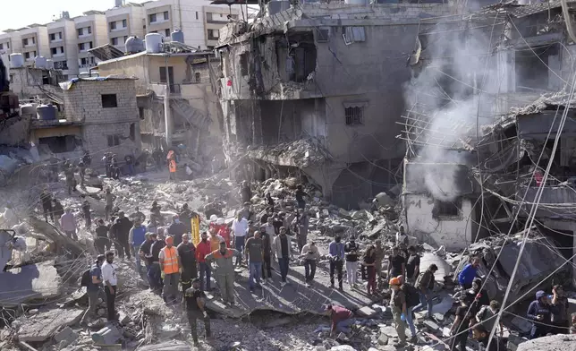 Rescue workers search for victims at the site of Israeli airstrikes that destroyed buildings facing the city's main government hospital in a densely-populated neighborhood, in southern Beirut, Lebanon, Tuesday, Oct. 22, 2024. (AP Photo/Hussein Malla)