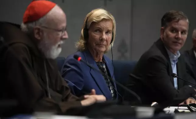 Jurist Maud de Boer-Buquicchio, center, and Clergy sex abuse survivor and victim's advocate Juan Carlos Cruz, right, listen to Cardinal Sean Patrick O' Malley speaking during a press conference to present the Vatican's first Annual Global Report on Minors Protection at the Vatican press center, Tuesday, Oct. 29, 2024. (AP Photo/Alessandra Tarantino)