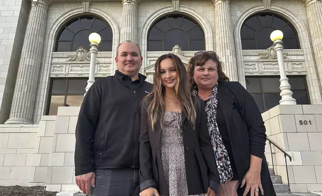 Kaylin Hayman, 17, poses with her parent's Mark and Shalene Hayman outside Ventura City Hall in Ventura, Calif., Oct. 17, 2024. (AP Photo/Eugene Garcia)