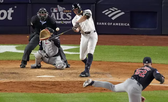 New York Yankees' Giancarlo Stanton, center, hits a home run off Cleveland Guardians relief pitcher Erik Sabrowski (62) during the seventh inning in Game 1 of the baseball AL Championship Series Monday, Oct. 14, 2024, in New York. (AP Photo/Seth Wenig)