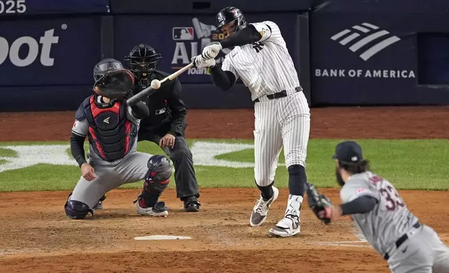 New York Yankees' Aaron Judge, center, hits a two-run home run off Cleveland Guardians relief pitcher Hunter Gaddis (33) during the seventh inning in Game 2 of the baseball AL Championship Series Tuesday, Oct. 15, 2024, in New York. (AP Photo/Seth Wenig)