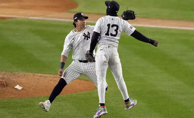 New York Yankees' Jazz Chisholm Jr. (13) and Oswaldo Cabrera celebrate after Game 1 of the baseball AL Championship Series against the Cleveland Guardians Monday, Oct. 14, 2024, in New York. The Yankees won 5-2. (AP Photo/Seth Wenig)