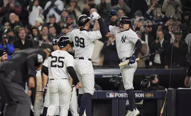 New York Yankees' Aaron Judge (99) celebrates with Austin Wells after hitting a two-run home run against the Cleveland Guardians during the seventh inning in Game 2 of the baseball AL Championship Series Tuesday, Oct. 15, 2024, in New York. (AP Photo/Frank Franklin II)