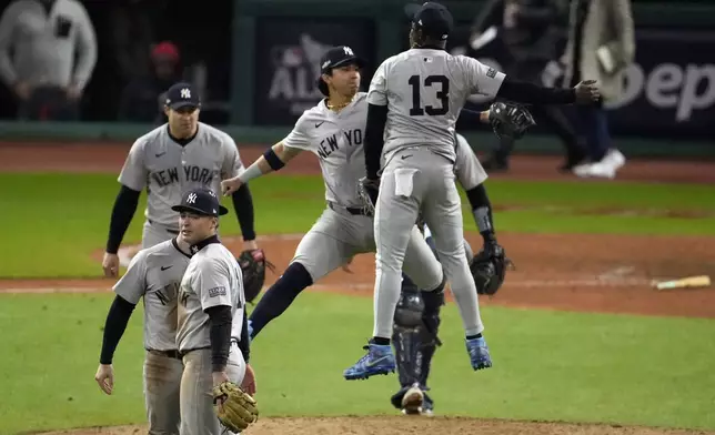 New York Yankees' Jazz Chisholm Jr. (13) and Oswaldo Cabrera celebrate after Game 4 of the baseball AL Championship Series against the Cleveland Guardians Friday, Oct. 18, 2024, in Cleveland. The Yankees won 8-6 to take a 3-1 lead in the best-of-seven series. (AP Photo/Jeff Roberson)