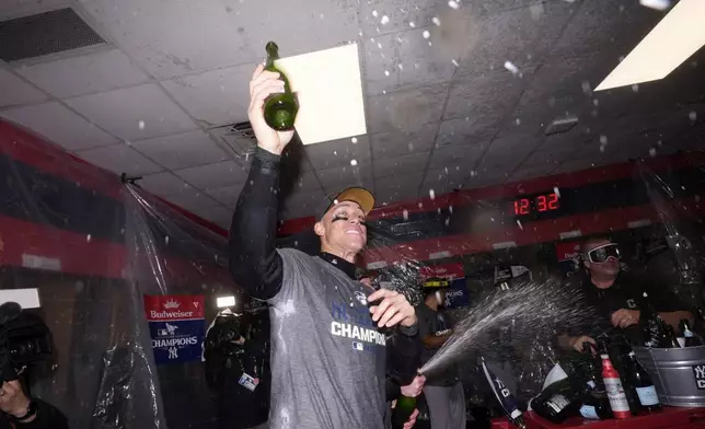 New York Yankees' Aaron Judge celebrates in the clubhouse after Game 5 of the baseball AL Championship Series against the Cleveland Guardians Sunday, Oct. 20, 2024, in Cleveland. The Yankees won 5-2 to advance to the World Series. (AP Photo/Godofredo A. Vásquez )